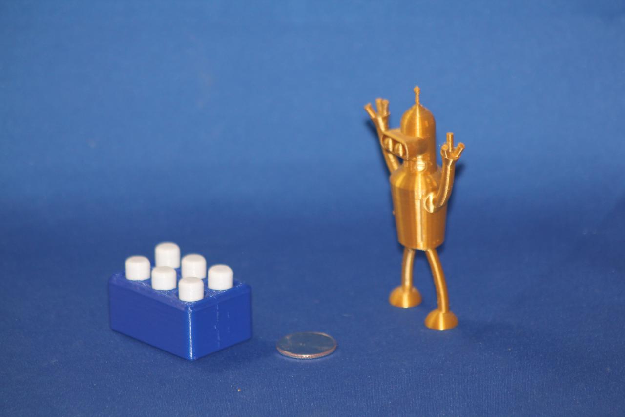 A golden Bender unit confronts a quarter and a Braille block, against a blue background..