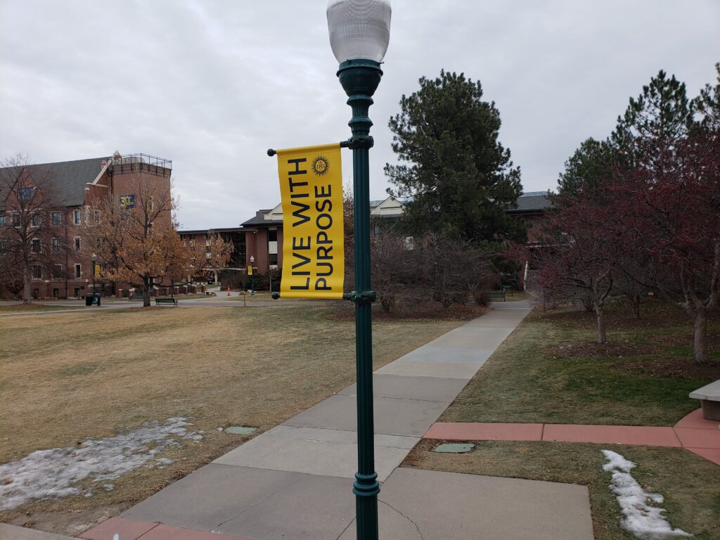 A lamp post with a yellow banner that states "Live with Purpose"